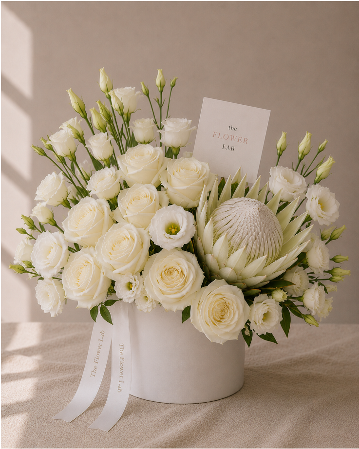 Eternal White – Arreglo de rosas blancas, lisianthus y protea king en base de cerámica